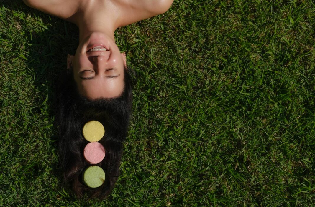 Young,Woman,Laying,On,The,Grass,With,Natural,Eco,Friendly